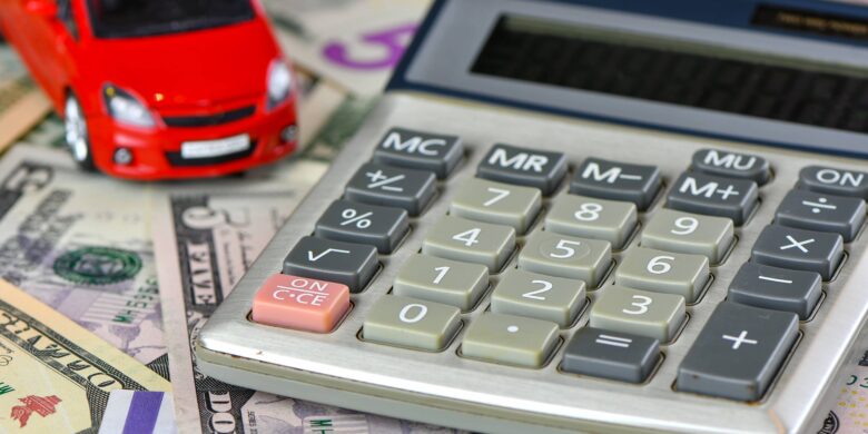 Calculatrice permettant de calculer son financement et voiture rouge jouet sur une variété de billets en monnaie nationale fond
